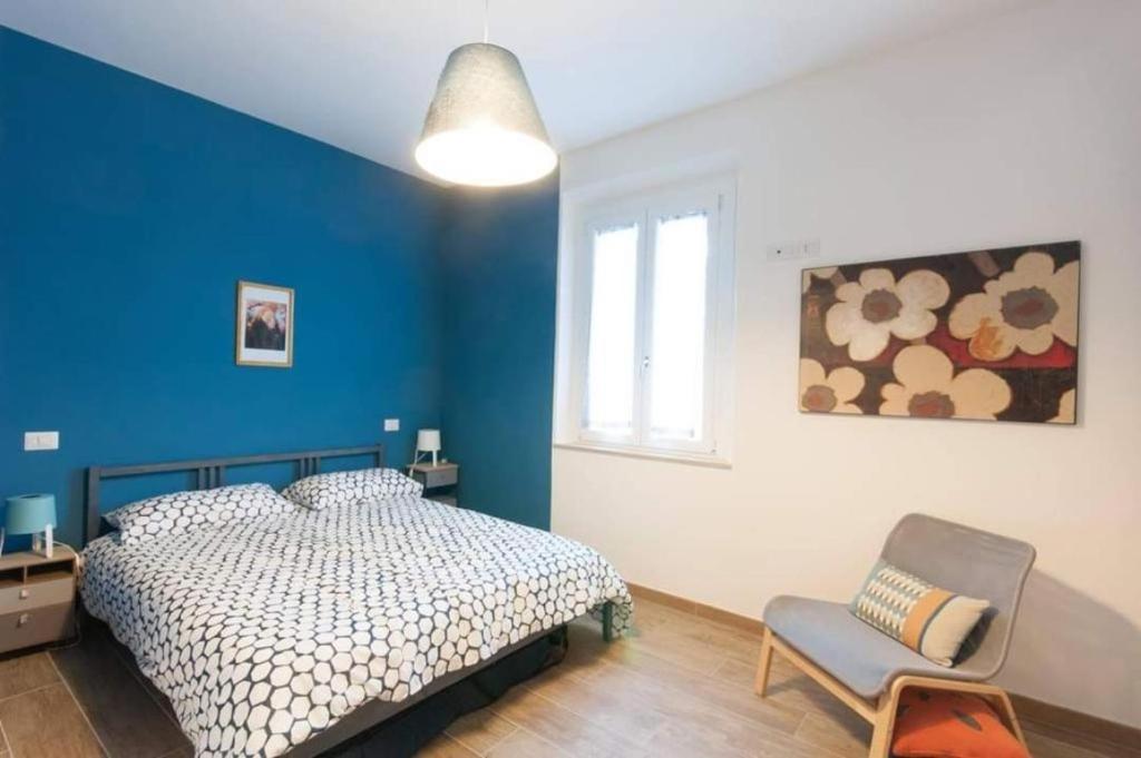 a bedroom with a bed and a blue wall at Bellissimo Appartamento a Perugia in Perugia