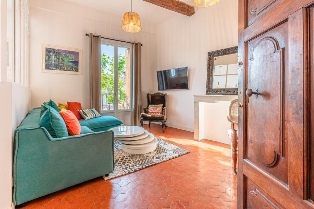 un salon avec un canapé vert et une table dans l'établissement La petite cigale by K6conciergerie, à Cassis