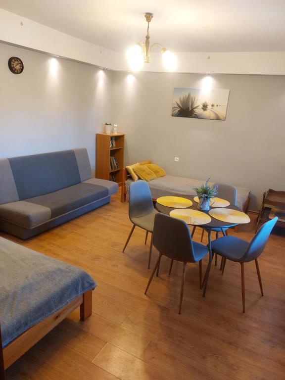 ein Wohnzimmer mit einem Sofa, einem Tisch und Stühlen in der Unterkunft Zakątek na Krzywej in Mrągowo