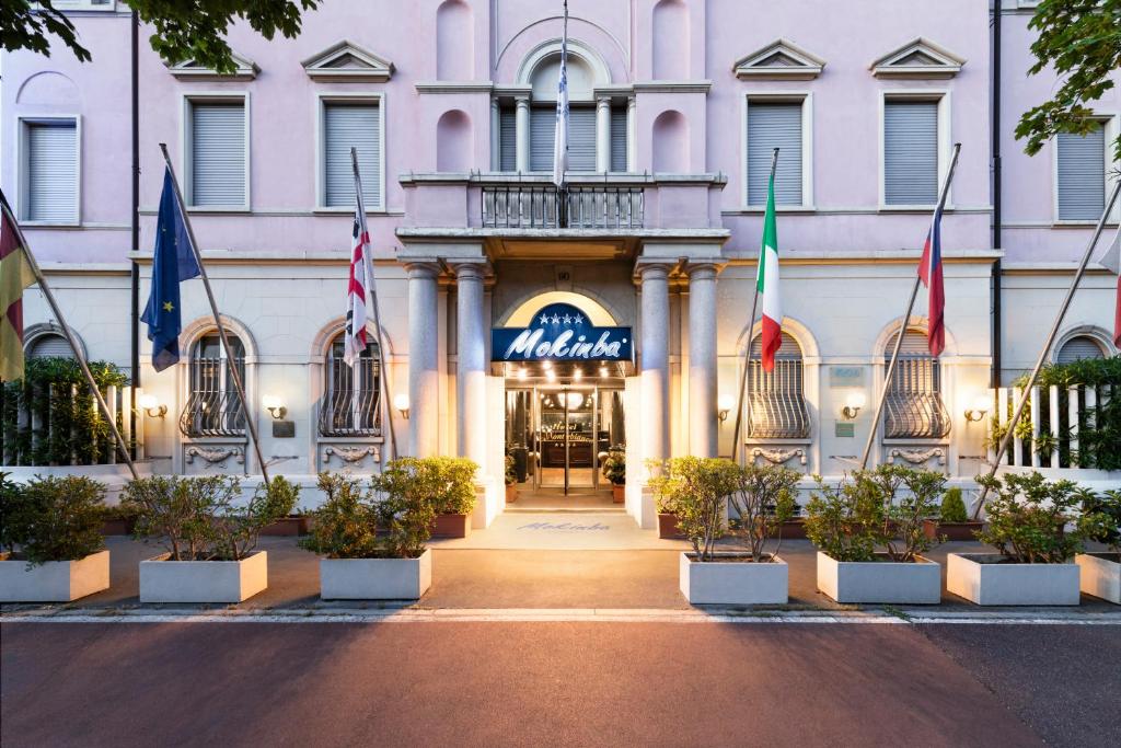 a hotel with flags in front of a building at Mokinba Hotels Montebianco in Milan