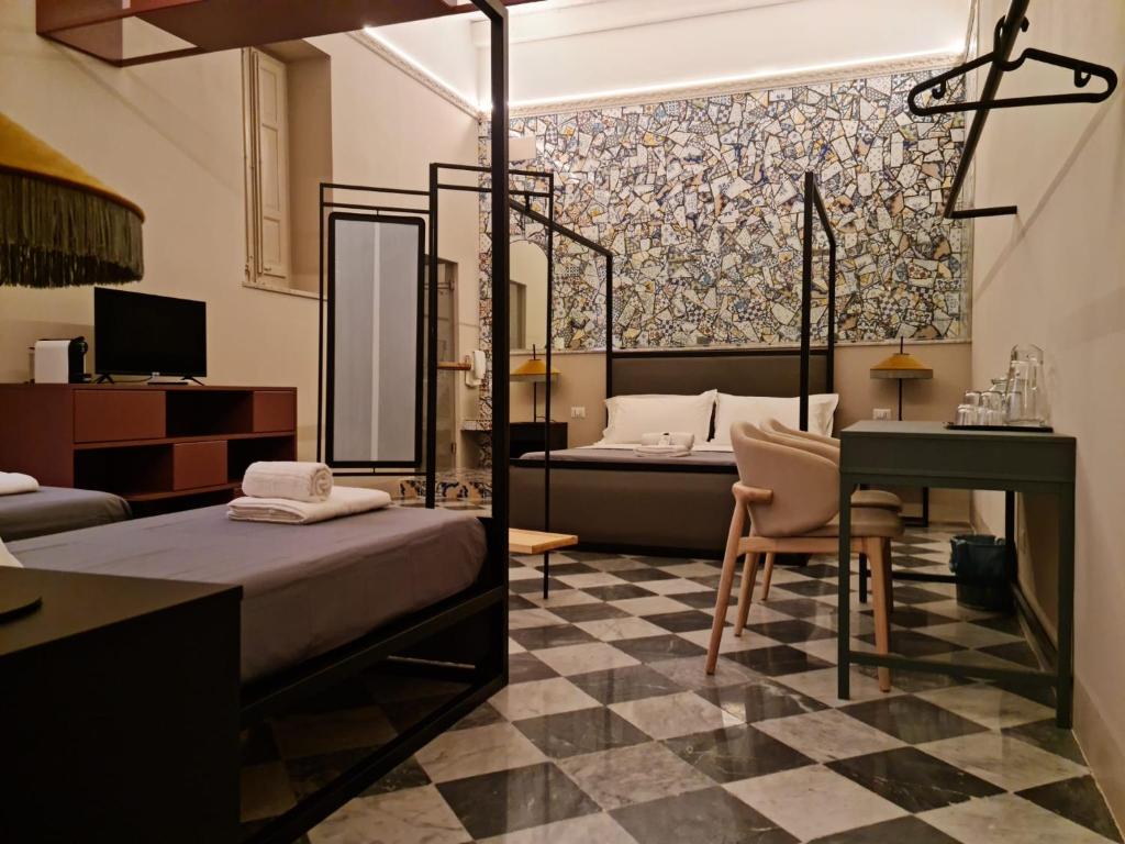 - une chambre avec 2 lits, une table et un bureau dans l'établissement Mamamia al Teatro Biondo, à Palerme