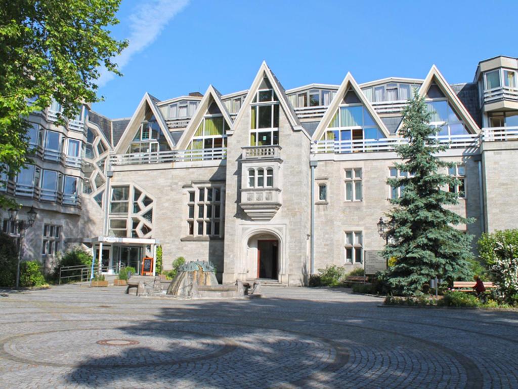 un gran edificio de ladrillo con un árbol delante de él en Hotel St.-Michaels-Heim en Berlín