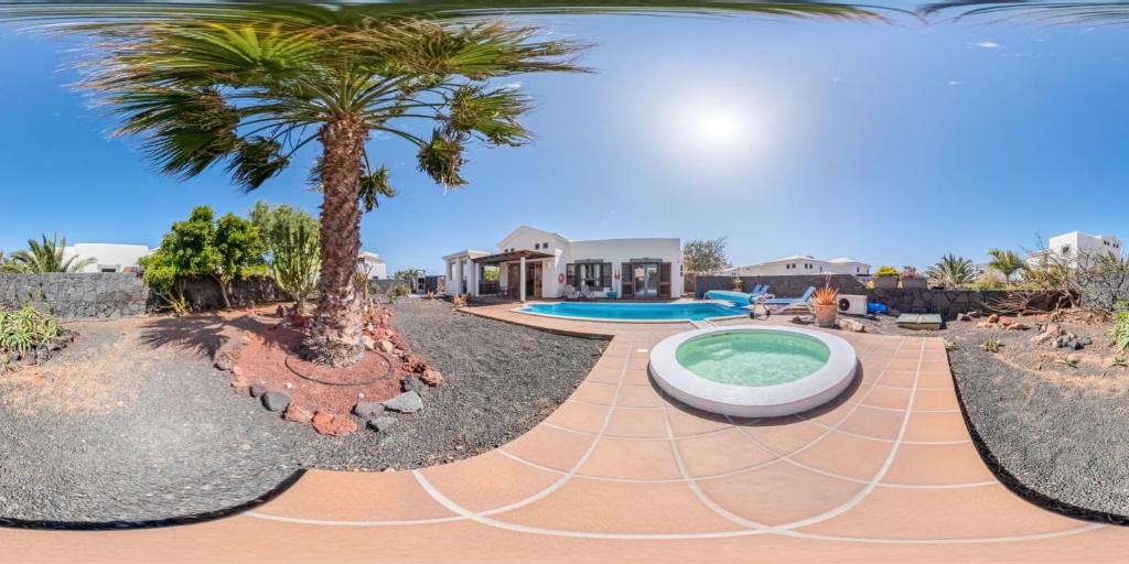 een villa met een zwembad en een palmboom bij Villa Marina Deluxe & Spa Pool in Playa Blanca