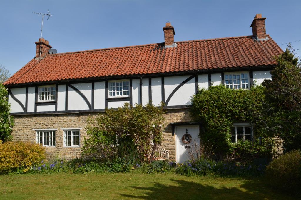 a black and white house with a red roof at BohemianBreezeBreaks in Thornton Dale