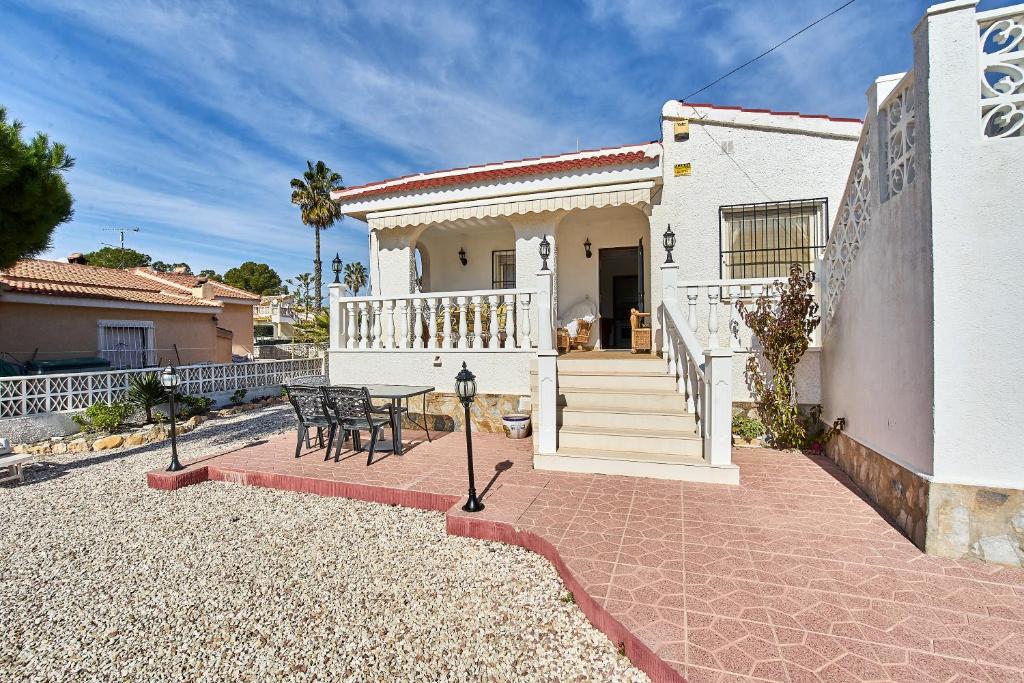 a white house with a patio and a table at Espanhouse Villa in Ciudad Quesada for 4 in Ciudad Quesada