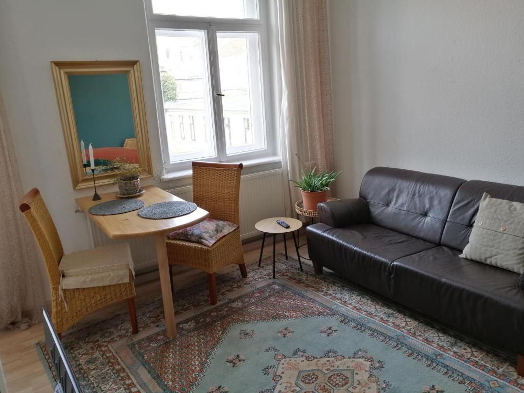ein Wohnzimmer mit einem Sofa und einem Tisch in der Unterkunft Alberthof Zittau in Zittau