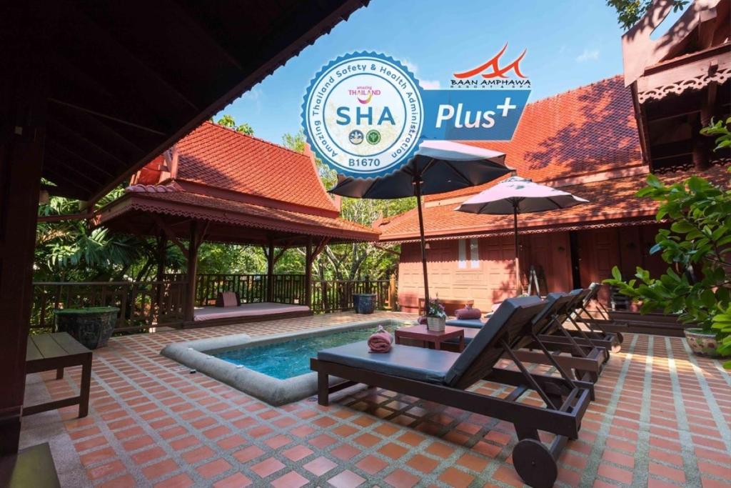a resort with a swimming pool and a sign at Baan Amphawa Resort & Spa - SHA Certified in Amphawa
