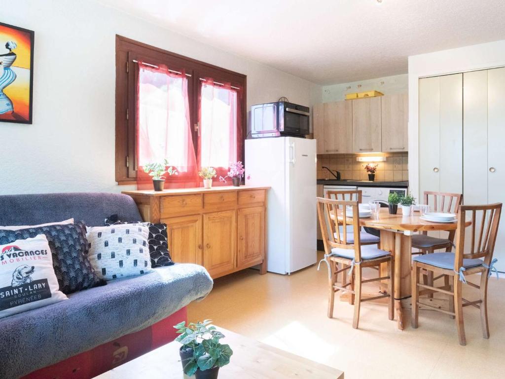 un salon avec un canapé et une table et une cuisine dans l'établissement Charmant T2 proche commerces et téléphérique avec navette gratuite et casier à skis - FR-1-296-368, à Saint-Lary-Soulan