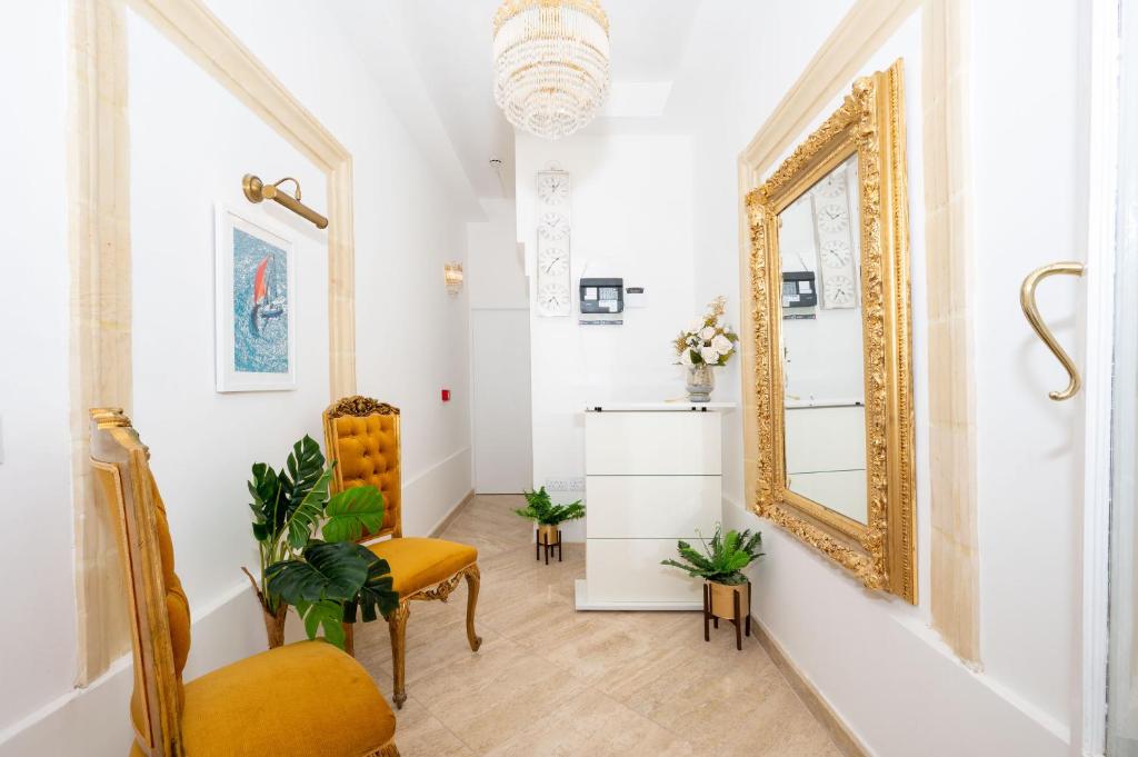 een woonkamer met een spiegel en een stoel bij Vela Blu Boutique Suites in Il-Gżira