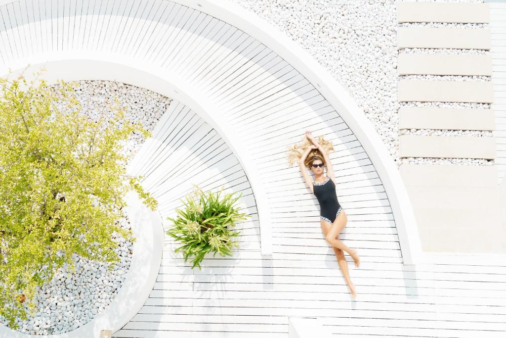 Une femme en robe noire sautant sur un escalier dans l'établissement White Hotel, à Vieste