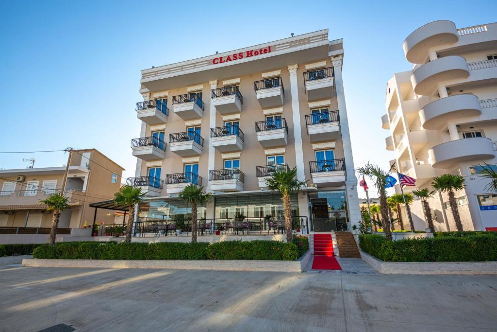 卡薩米里的住宿－CLASS Hotel，享有酒店前方棕榈树建筑的景致
