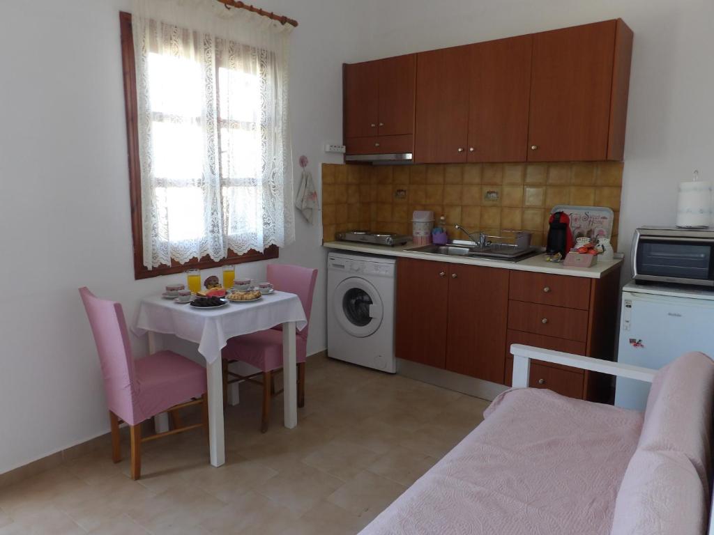 kuchnia ze stołem oraz niewielka kuchnia ze stołem i krzesłami w obiekcie TEO 1 Apartment w mieście Guwes
