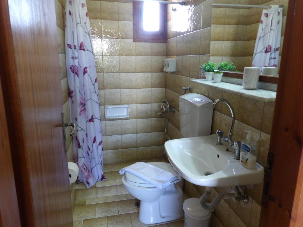 łazienka z toaletą i umywalką w obiekcie TEO 1 Apartment w mieście Guwes