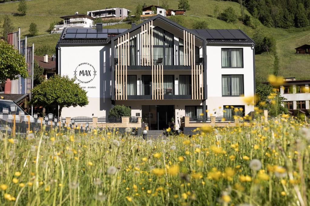 ein Gebäude mit einem Blumenfeld davor in der Unterkunft Max Mountain Apartments in Neustift im Stubaital