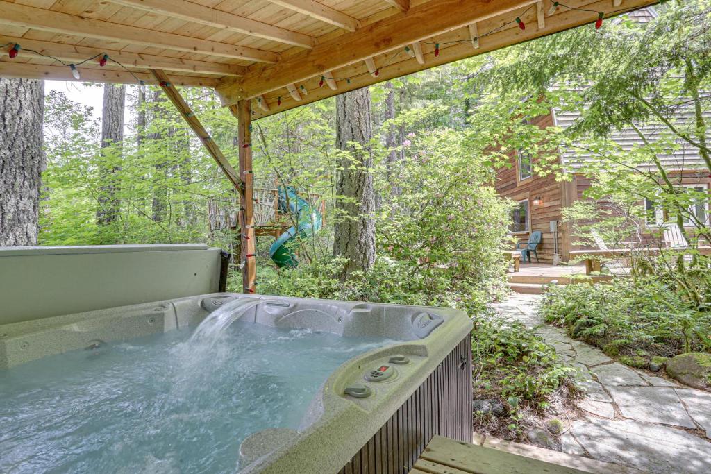 a hot tub in the middle of a backyard with a wooden roof at River Breeze Chalet - Meredith Lodging in Rhododendron