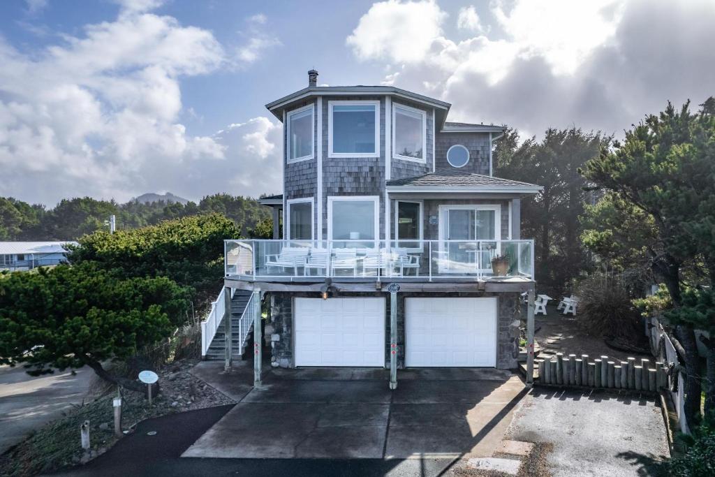 a house with a balcony and two garage doors at Beverly Beach Overlook in Newport