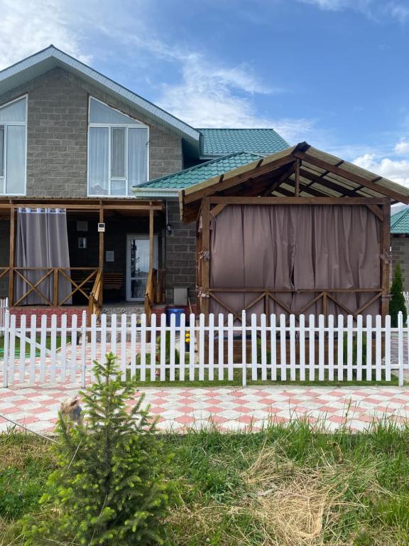 a house with a white fence in front of it at Коттедж в ЦО Париж in Chok-Tal