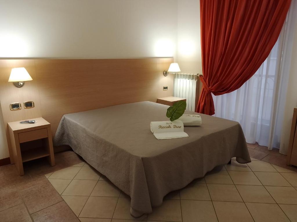 1 dormitorio con cama y cortina roja en B&B Riccioli D'oro en Margherita di Savoia