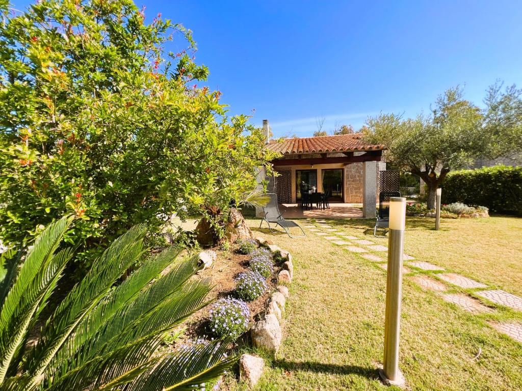 una casa con un cortile con un muro di pietra di Sa Perla Marina - FREE WIFI - 500 mt from the beach a Costa Rei