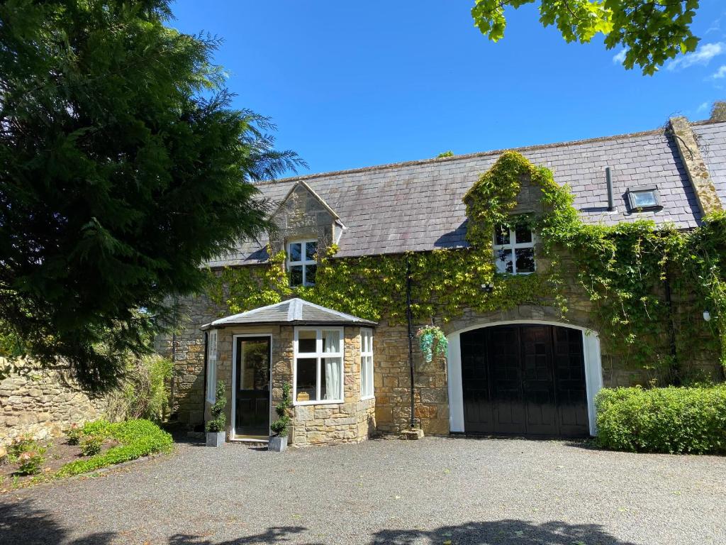 a brick house with a garage and a driveway at The Old Vicarage in Berwick-Upon-Tweed