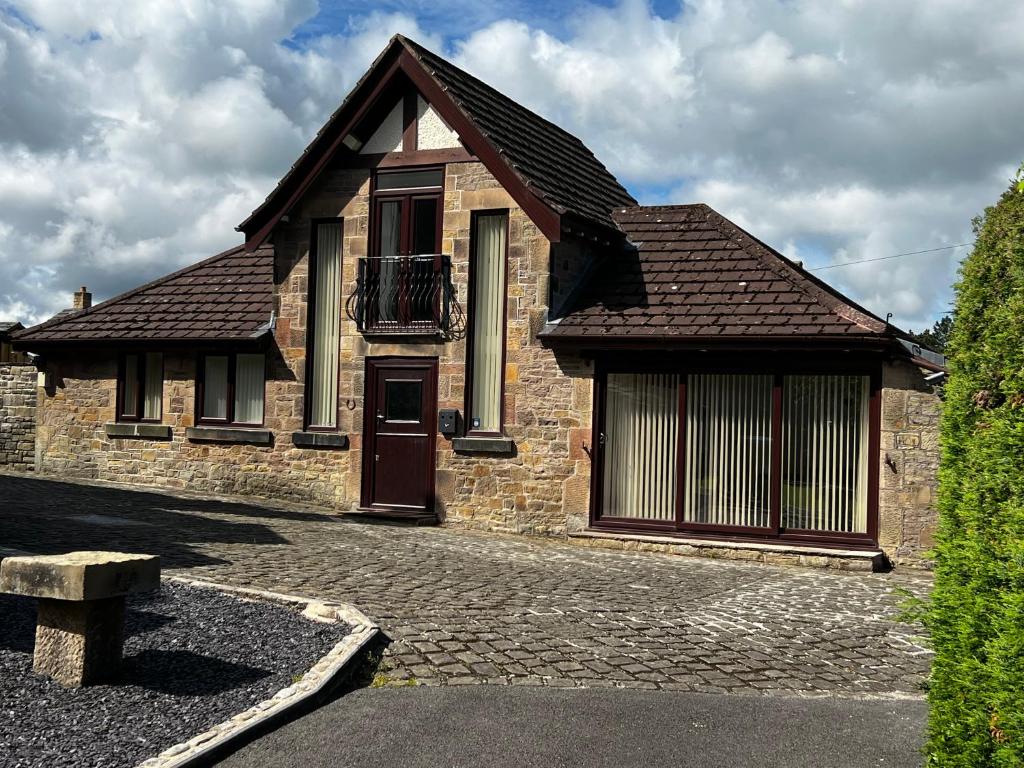 una casa in mattoni con finestra e porta di Castle House Holiday Home a Chapel-en-le-Frith