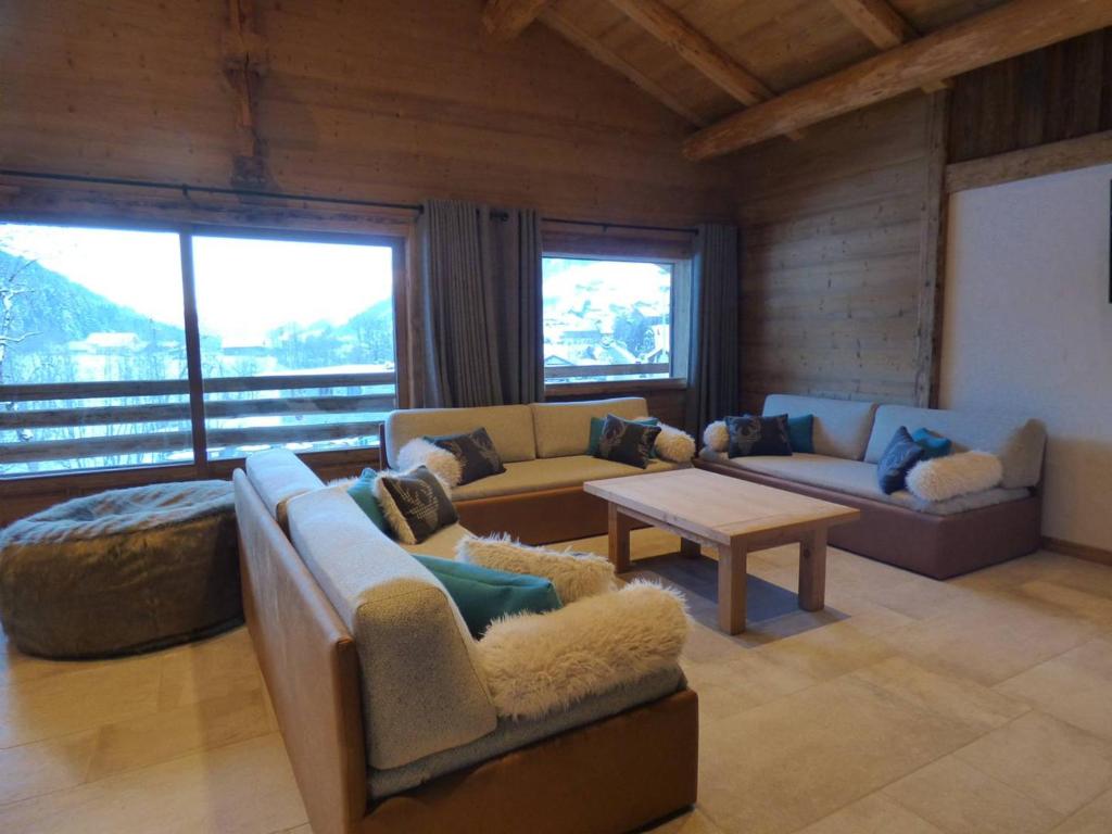 a living room with couches and a table andwindows at Appartement Le Grand-Bornand, 5 pièces, 14 personnes - FR-1-458-95 in Le Grand-Bornand