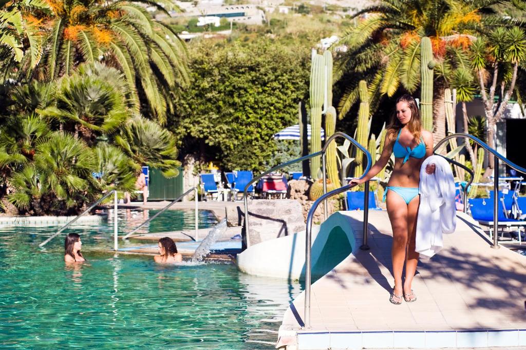 Una donna in bikini che cammina su uno scivolo in piscina di Park Hotel Terme Mediterraneo a Ischia