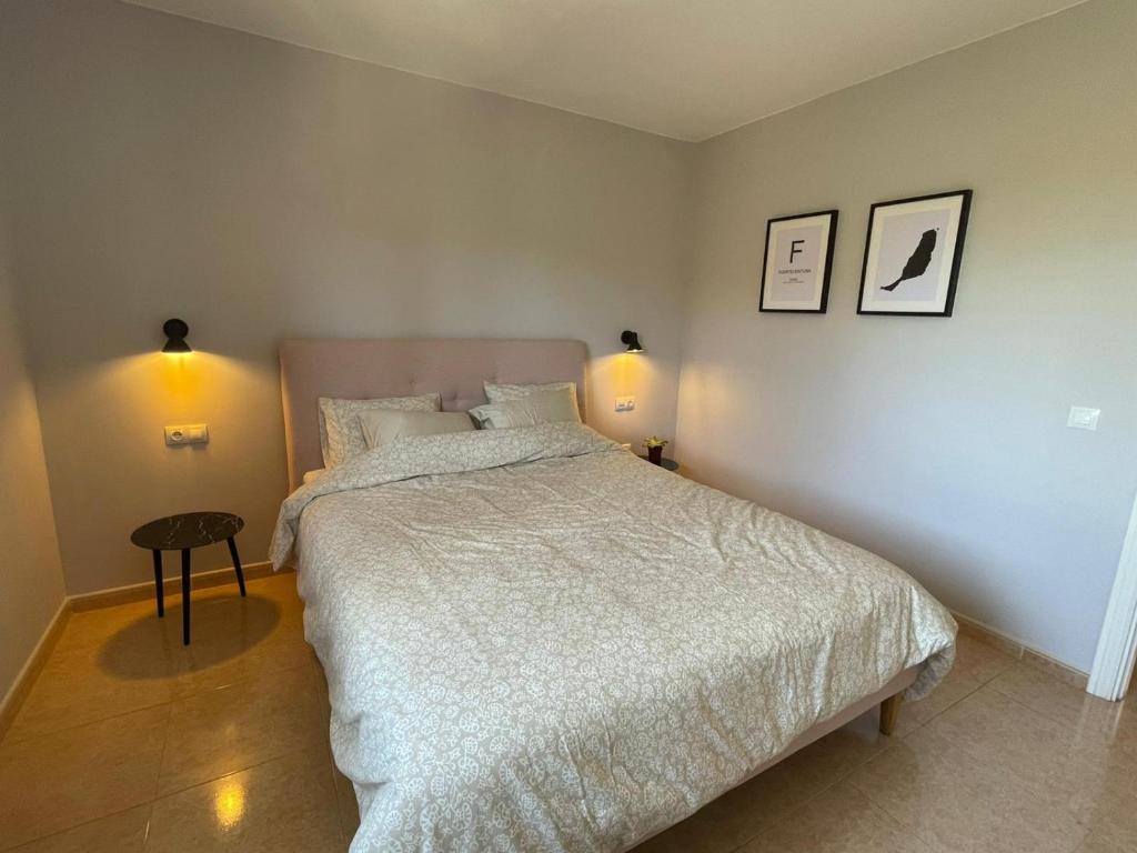 a bedroom with a bed and two pictures on the wall at Casa Cayenne - Stylish apartment with ocean/dune view in Corralejo