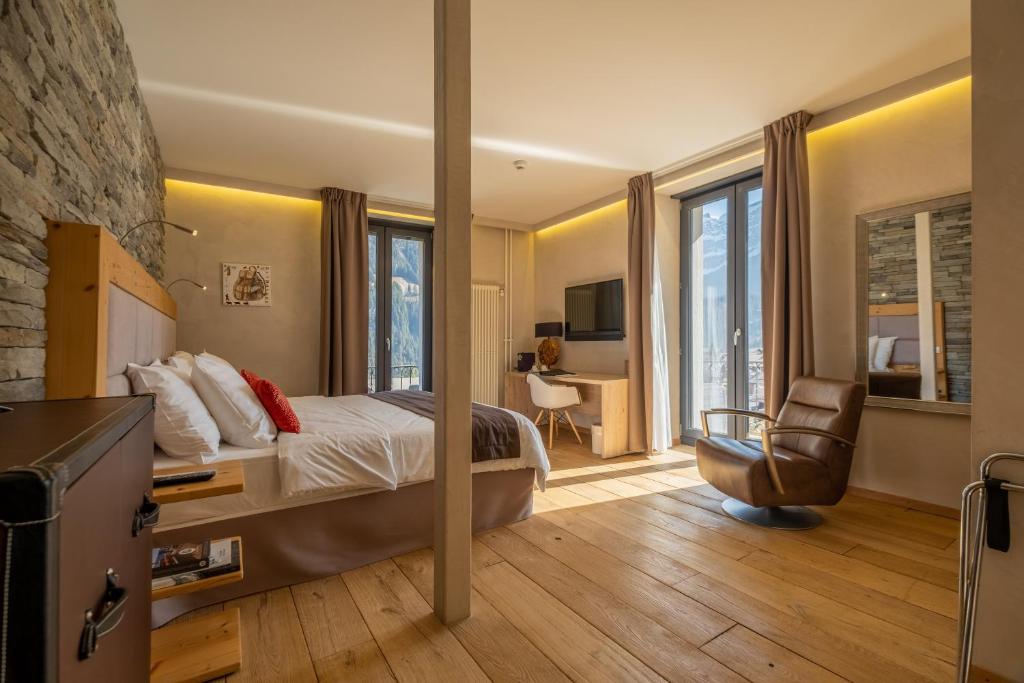 a bedroom with a bed and a desk and a chair at Hôtel National Resort & Spa in Champéry