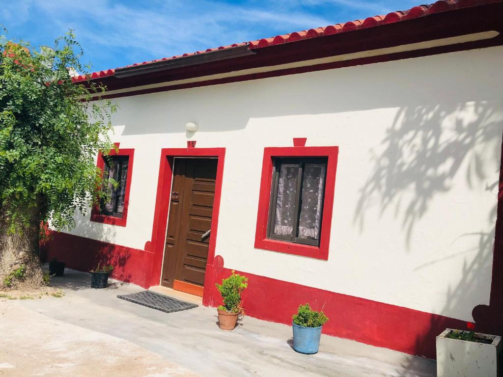 czerwono-biały dom z czerwonymi drzwiami w obiekcie Mãe Home Carril w mieście Caldas da Rainha