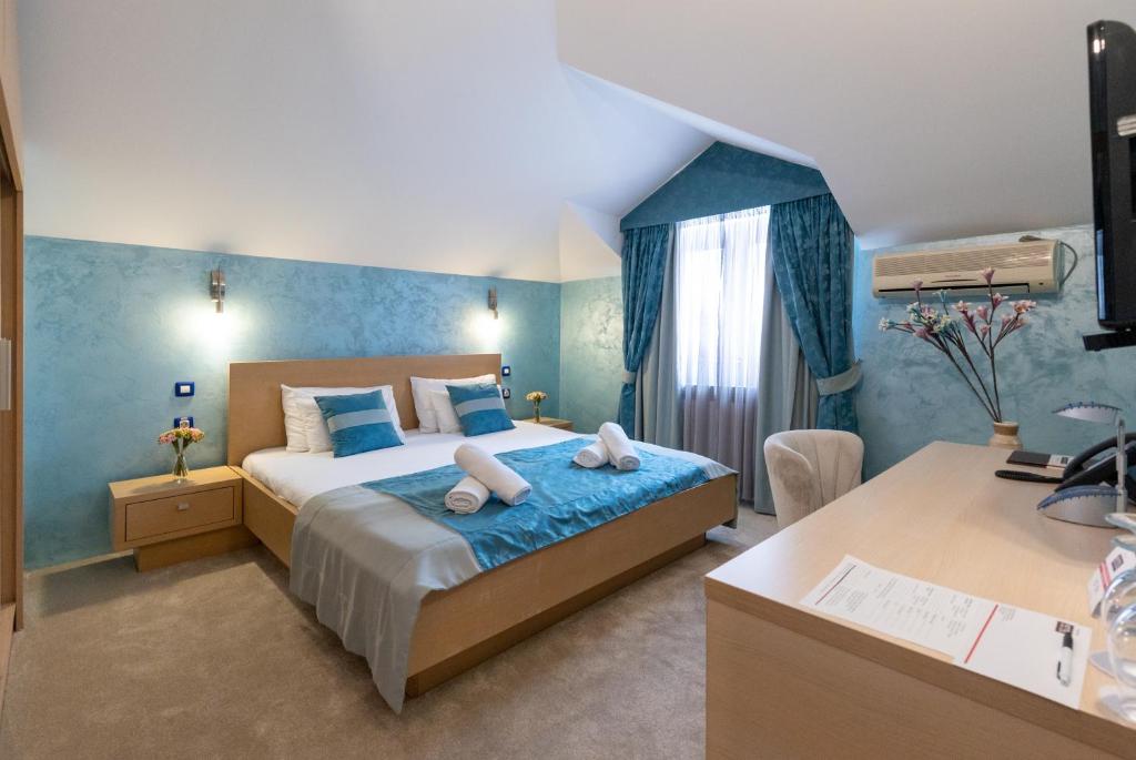 ein Schlafzimmer mit einem Bett mit zwei Handtüchern darauf in der Unterkunft Euro Garni Hotel in Belgrad