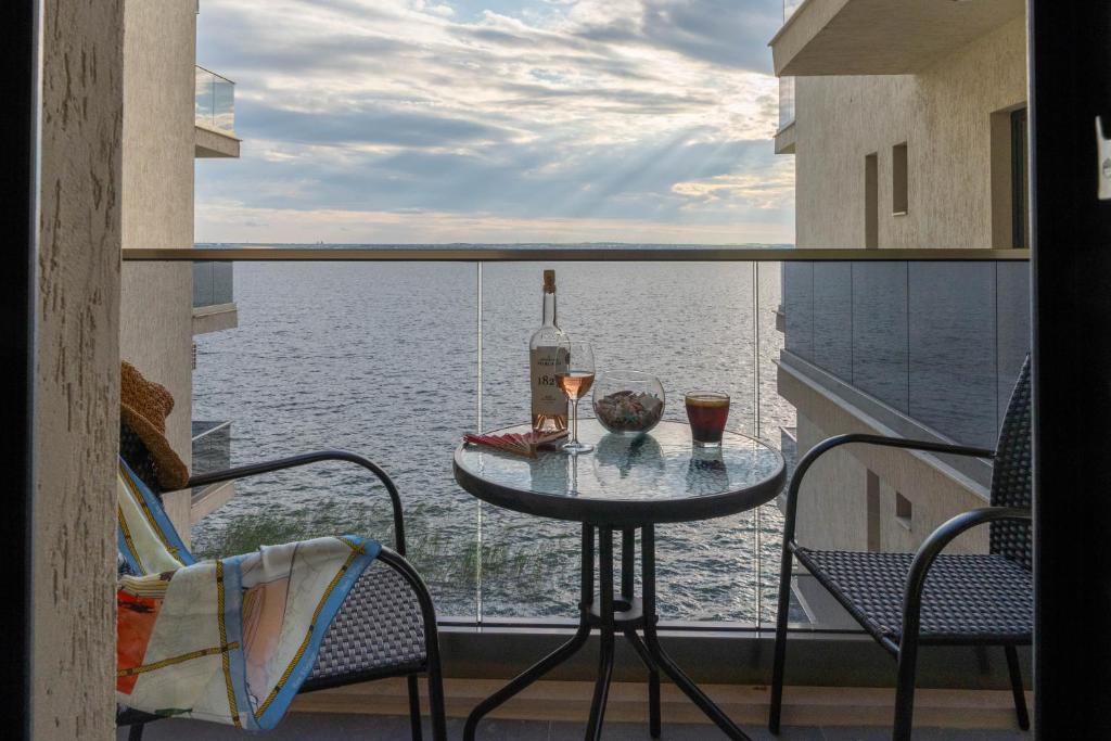 a balcony with a table and two glasses of wine at Apartament Le Bonheur Deux Solid Residence Butoaie in Mamaia