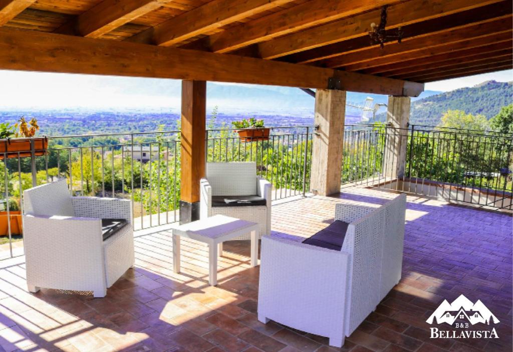 a patio with white chairs and a table and a view at B&B Bellavista in Celano