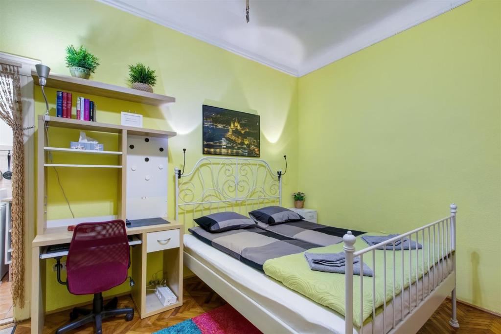 a bedroom with a bed and a desk and a chair at Margaret Apartment in Budapest