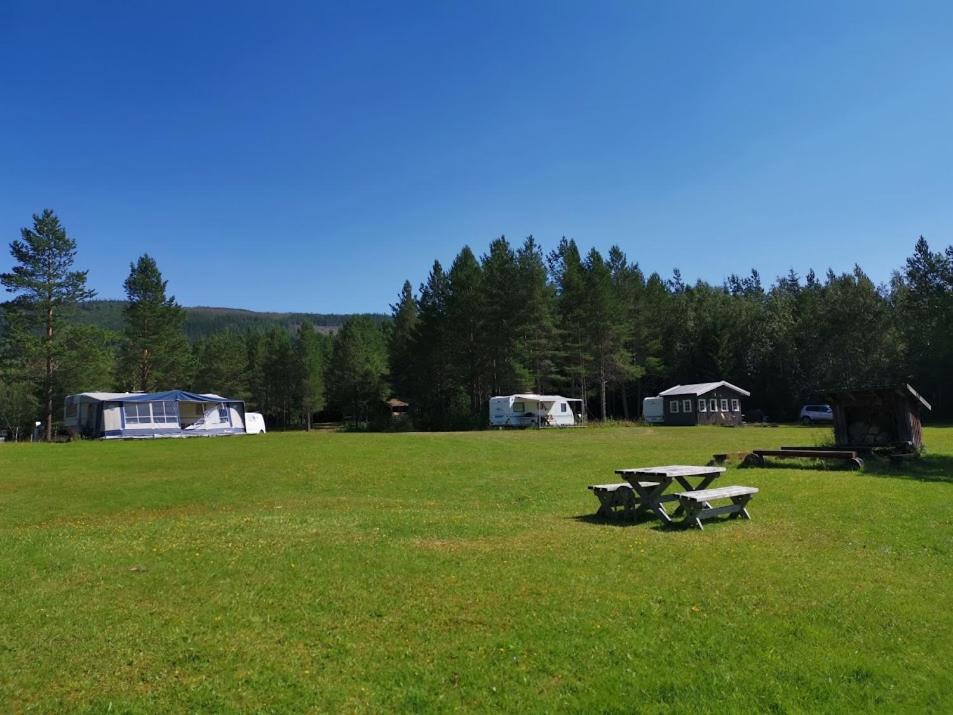 a park with two picnic tables in a field at Gresslifoss Camping in Gressli