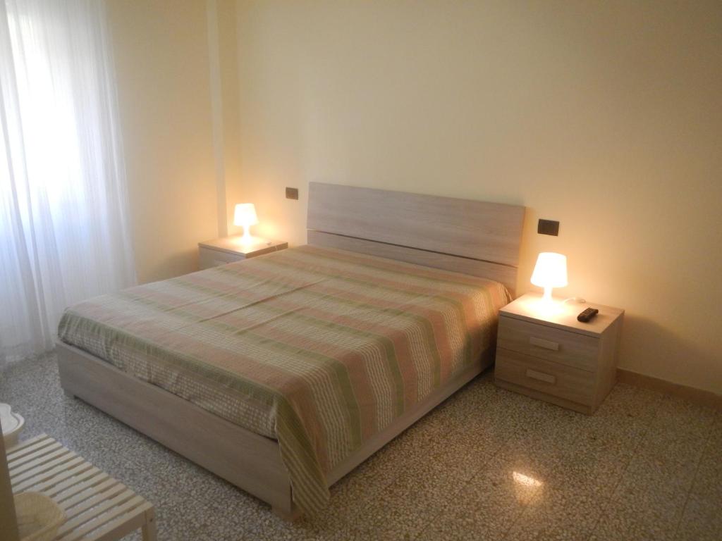 a bedroom with a bed and two night stands with lamps at guzzi b&b in Chieti
