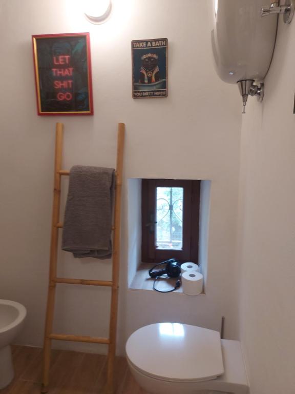a bathroom with a toilet and a shelf and a window at I Colori del Lago in Passignano sul Trasimeno