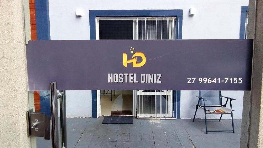 un panneau devant un bâtiment avec un dmg d'auberge de jeunesse dans l'établissement Hostel Diniz, à Vitória