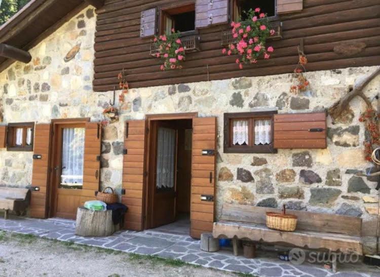 a building with a bench in front of it at Baita Palue in Torcegno