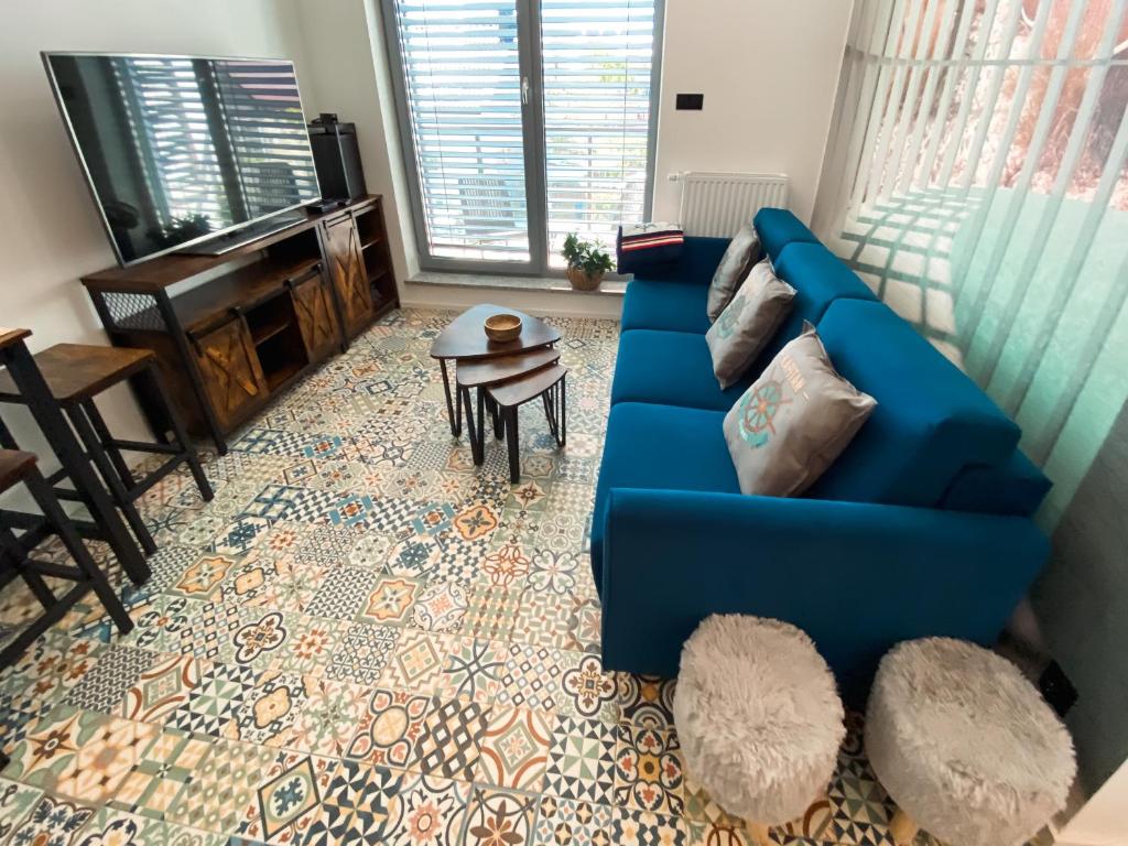ein Wohnzimmer mit einem blauen Sofa und einem Klavier in der Unterkunft Apartament TURKUS in Puck