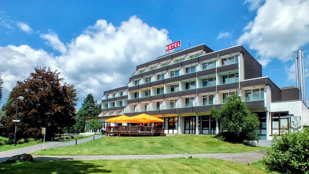 ein Hotelgebäude mit einer Liegewiese davor in der Unterkunft Parkhotel Olsberg in Olsberg