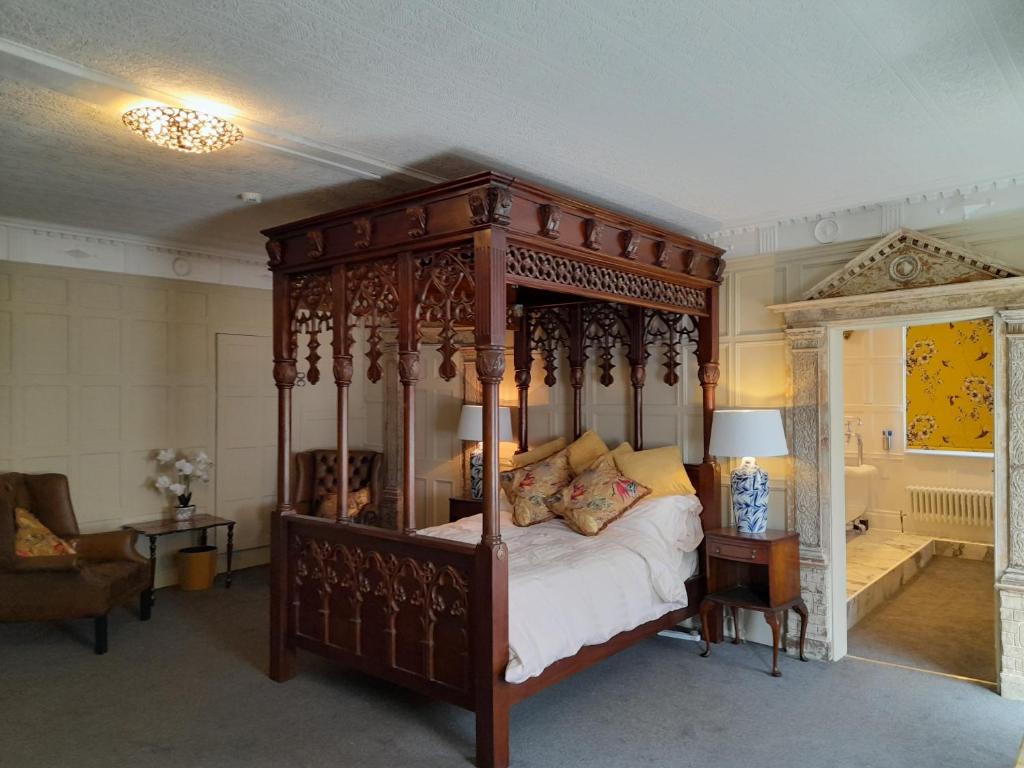 a bedroom with a canopy bed and a bathroom at Stone Court House in Maidstone