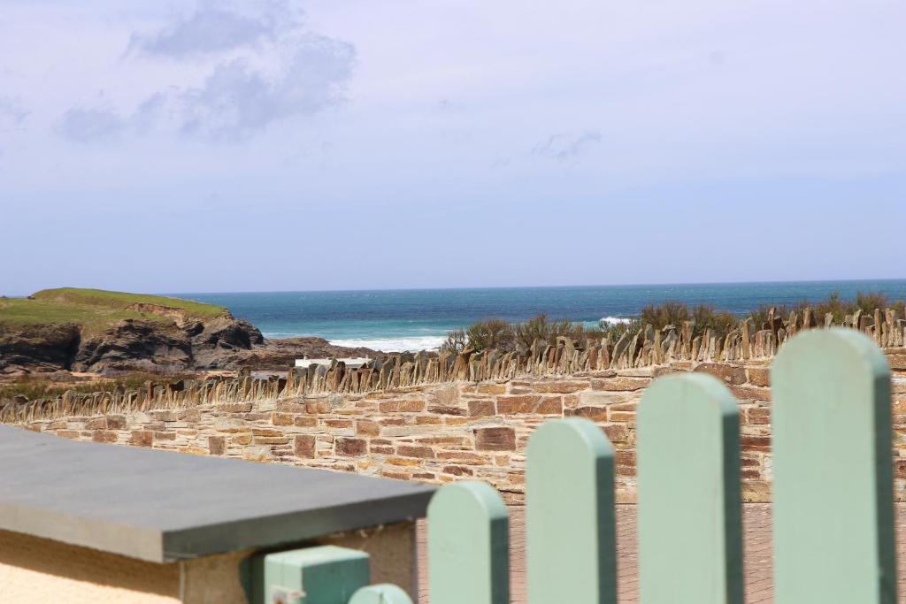 una panchina sulla spiaggia con una recinzione e l'oceano di APARTMENT BY THE BEACH, courtyard garden a Saint Merryn