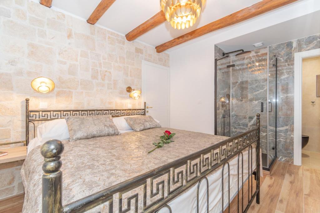 a bedroom with a large bed and a glass shower at Ivka Makarska - modern and luxurious oldtown apartament in Makarska