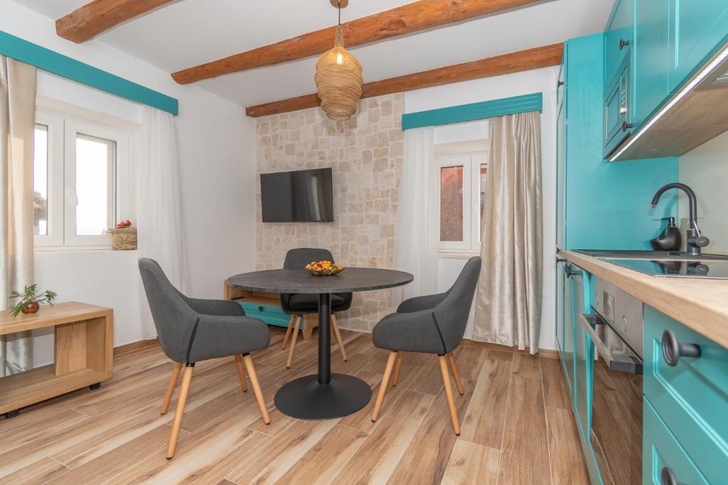 a kitchen and dining room with a table and chairs at Ivka Makarska - modern and luxurious oldtown apartament in Makarska
