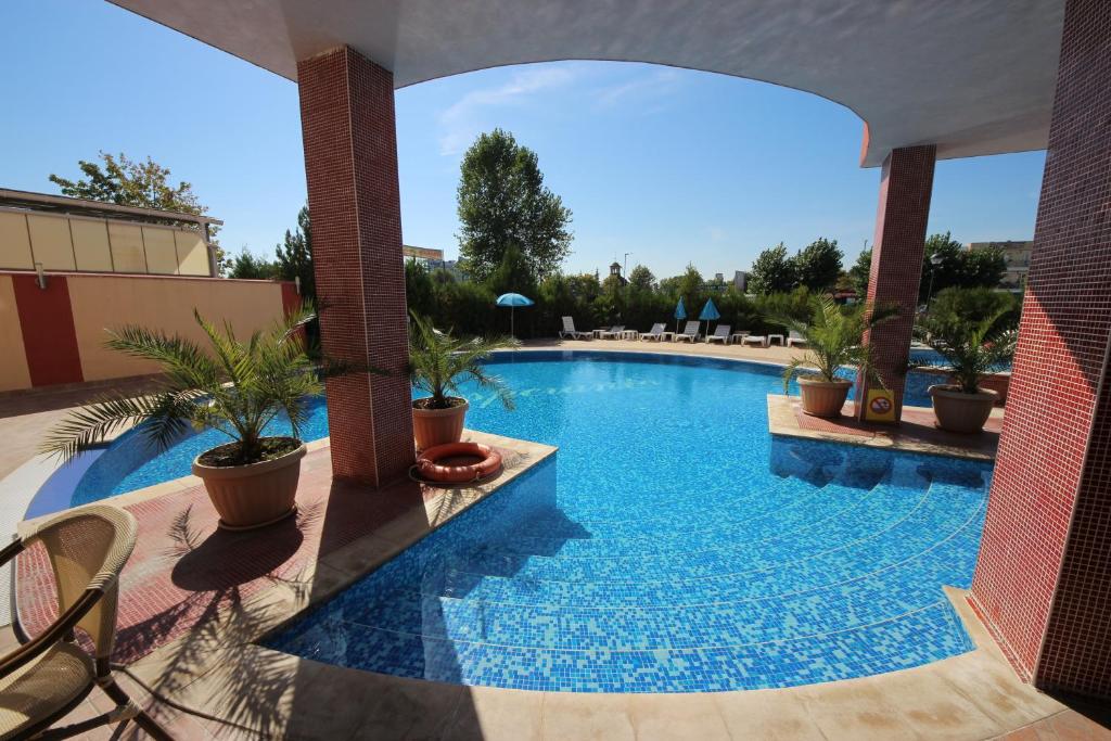 una piscina en un complejo con sillas y plantas en Menada Apartments in Sunny Beach, en Sunny Beach