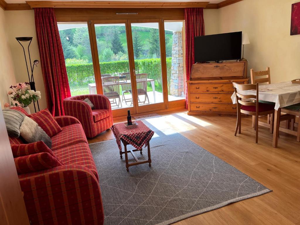 a living room with a couch and a table and a television at Studio - La Vièze Thermes Park in Val-d'Illiez