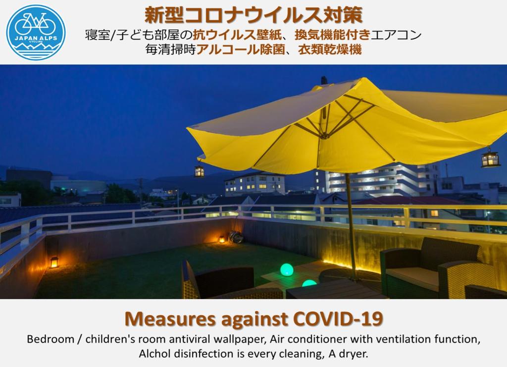 una sombrilla en el techo de un edificio por la noche en 一棟貸切 Cozy inn Saki -Family & Cyclists Welcome - en Matsumoto