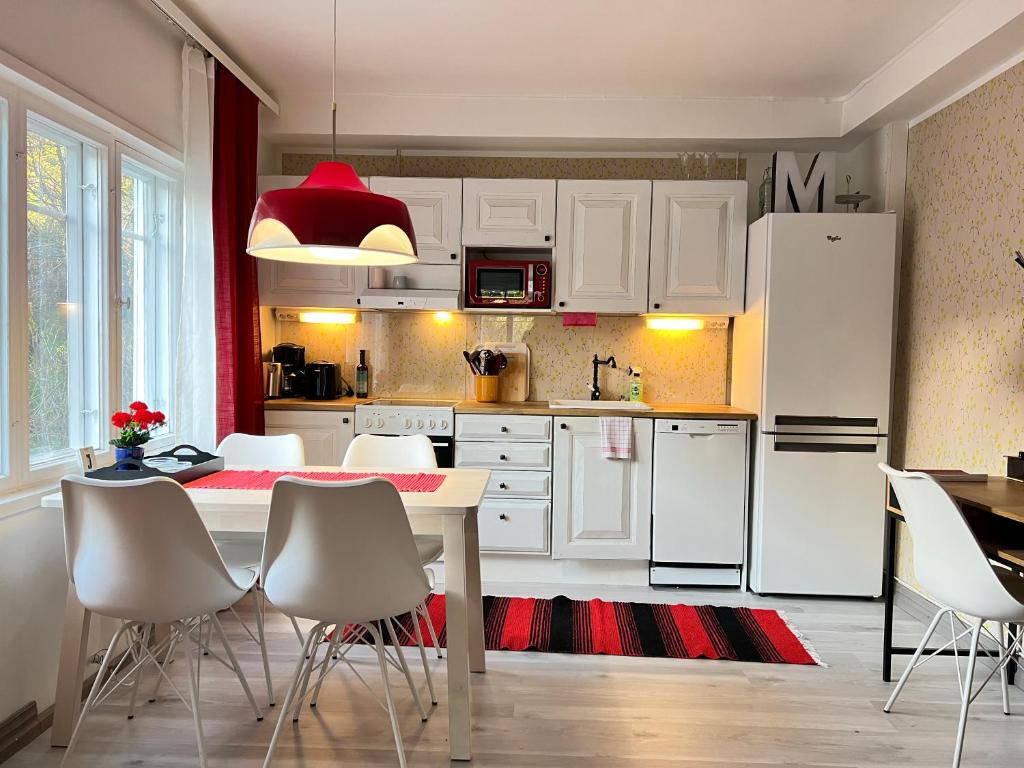 una cucina con elettrodomestici bianchi, tavolo e sedie di Time Apartment Jänönkuja a Jyväskylä