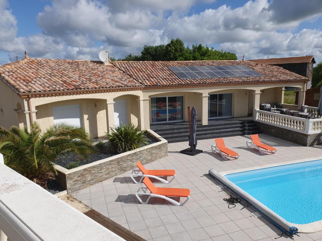 a house with a swimming pool and a house with a roof at villa 15 personnes avec piscine et terrain de pétanque in Puysserampion
